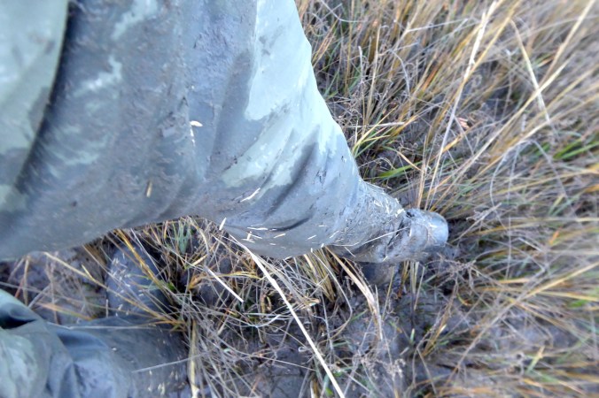 looking down on very muddy pants and footware