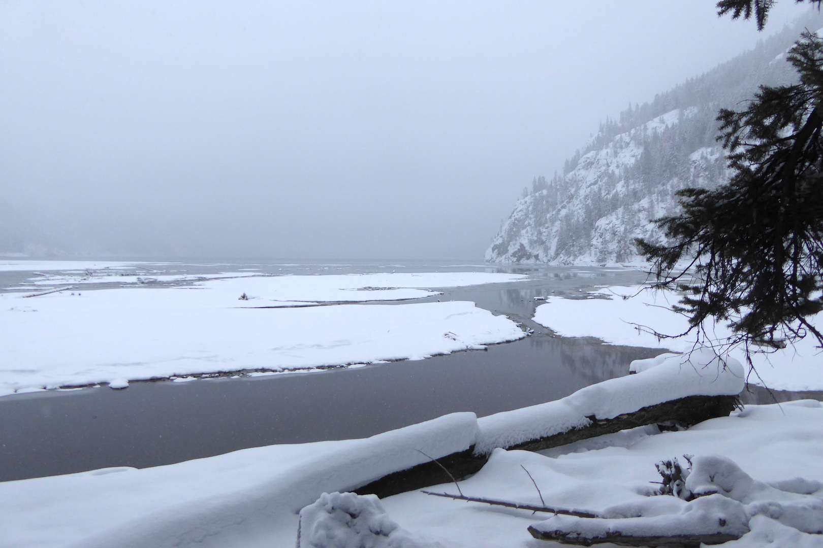 snow covered mud flats and steep mountainside