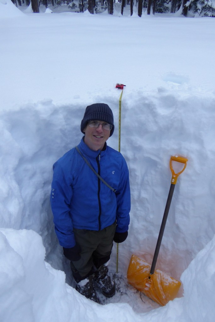 Person standing in deep snow pit. Pit is 65 inches deep.