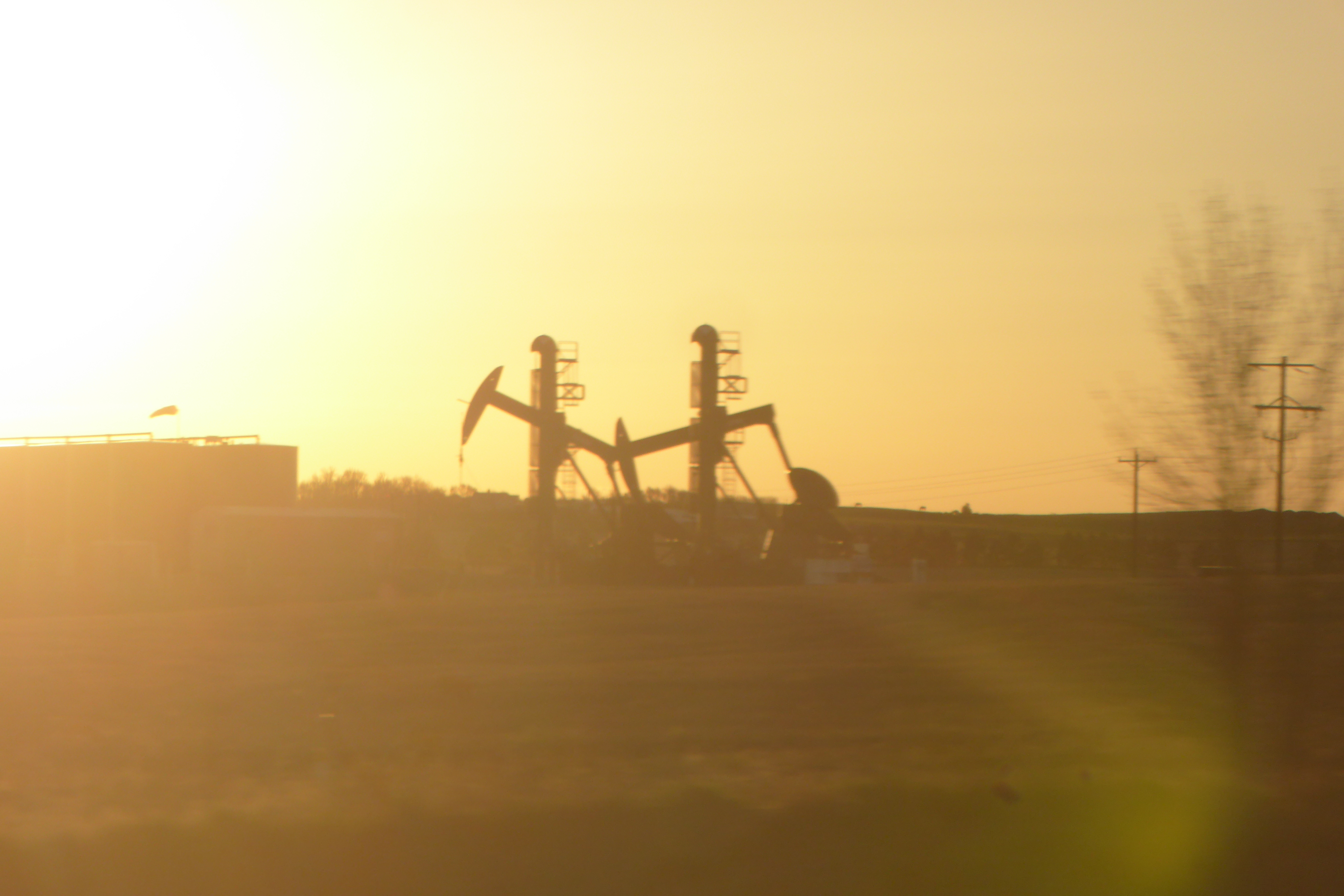 oil wells silhouetted by the setting sun
