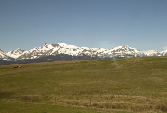 rolling prairie with snow-capped mountains in background