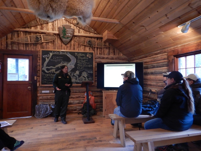 Ranger in log cabin talking to people