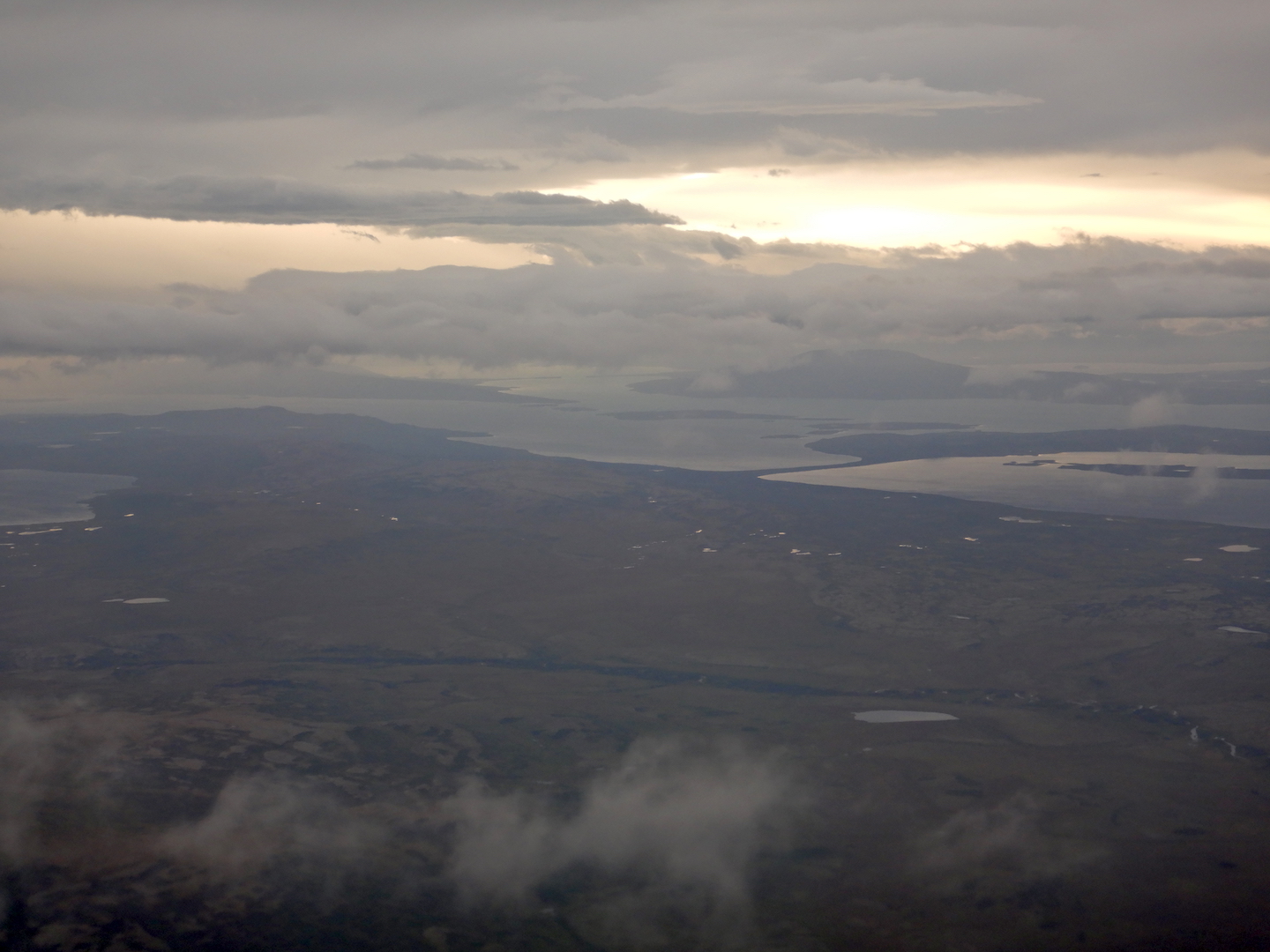 Aerial view of land, lake, and clouds.