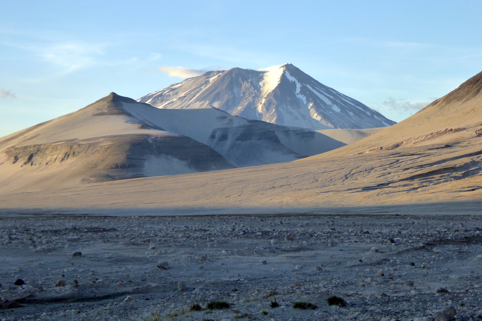 pumice covered landscape with volcano in background