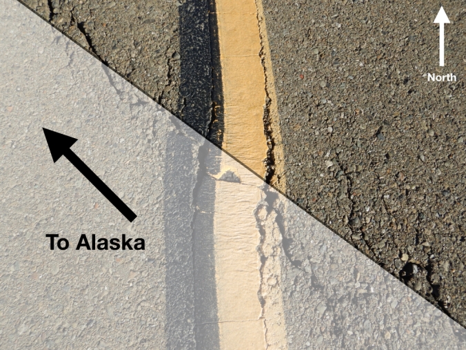 Road pavement with crack. Text reads "To Alaska" and "North"