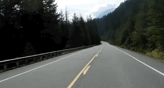 GIF of road and surrounded by mountains and trees
