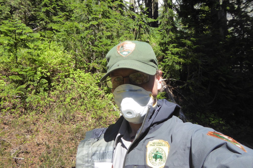Selfie of ranger wearing NPS hat, black coat, and N95 mask