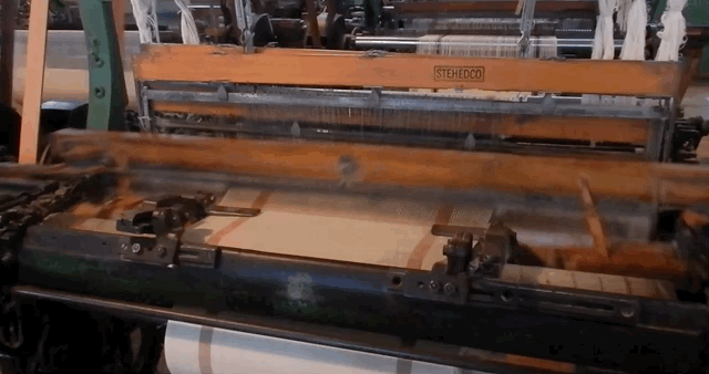 GIF of industrial weaving loom from 1920s. Rods move forward and back, up and down, to drive cotton threads into cloth.